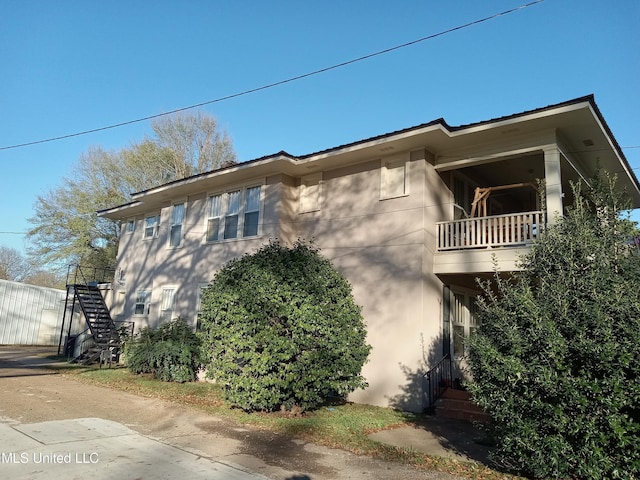 107 E Percy St, Indianola, MS 38751 - view of property exterior with stairway, a balcony, and stucco siding