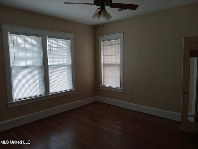 107 E Percy St, Indianola, MS 38751 - spare room featuring a ceiling fan, dark wood-type flooring, and baseboards