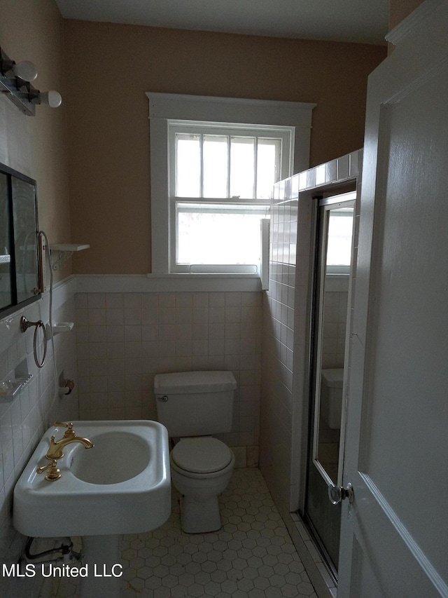 107 E Percy St, Indianola, MS 38751 - bathroom with toilet, tile walls, tile patterned flooring, a wainscoted wall, and a sink