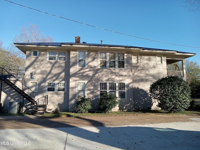 107 E Percy St, Indianola, MS 38751 - view of home's exterior with stairway, stucco siding, central air condition unit, and a chimney