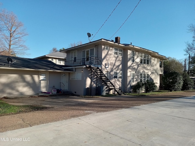 107 E Percy St, Indianola, MS 38751 - rear view of house featuring stairway and stucco siding