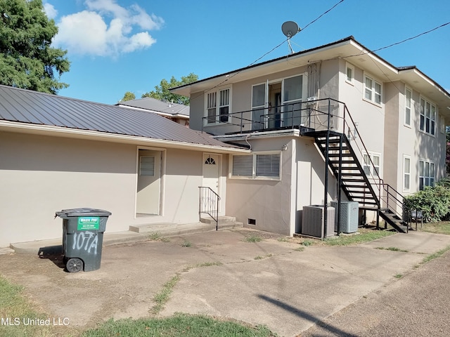 107 E Percy St, Indianola, MS 38751 - back of house with stairs, stucco siding, metal roof, and cooling unit