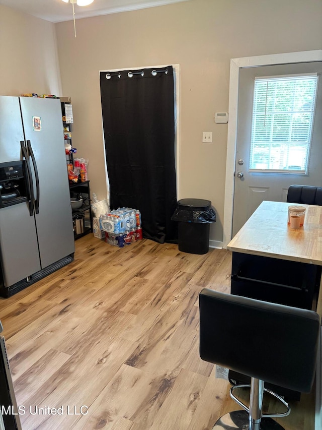 interior space with light wood-type flooring and stainless steel refrigerator with ice dispenser