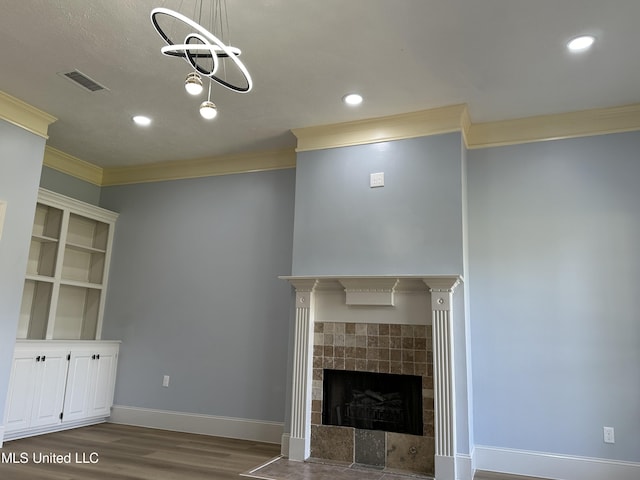 124 Holmar Dr, Brandon, MS 39047 - unfurnished living room with ornamental molding, wood finished floors, a tiled fireplace, baseboards, and recessed lighting