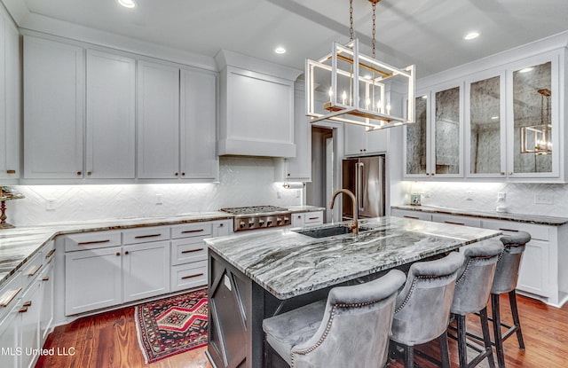 102 Silverleaf Dr, Madison, MS 39110 - kitchen featuring appliances with stainless steel finishes, a sink, decorative backsplash, light stone counters, and wood finished floors