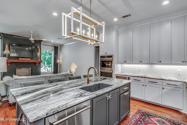 102 Silverleaf Dr, Madison, MS 39110 - kitchen with a sink, open floor plan, stainless steel appliances, light wood-type flooring, and decorative light fixtures