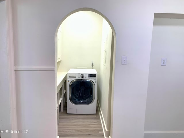 laundry room with light hardwood / wood-style floors, washer / clothes dryer, and cabinets