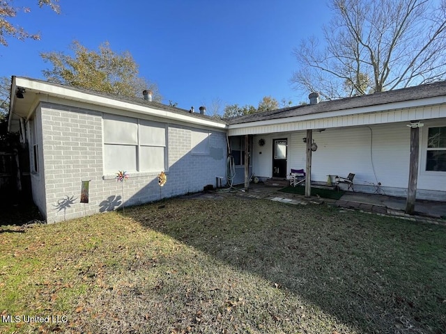 back of property featuring a lawn