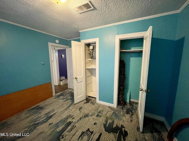 bedroom featuring a textured ceiling, a closet, and ornamental molding