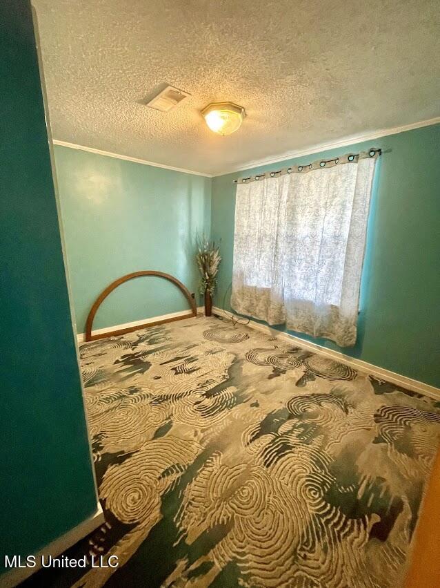 bedroom with crown molding and a textured ceiling