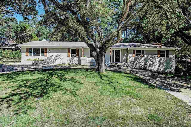 ranch-style home featuring a front lawn