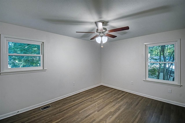 unfurnished room with visible vents, a ceiling fan, a textured ceiling, dark wood finished floors, and baseboards