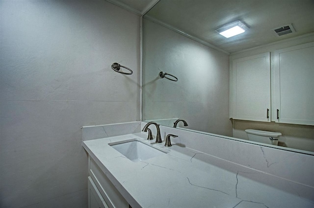 bathroom with visible vents, toilet, and vanity