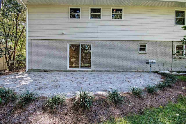 back of house with a patio and brick siding