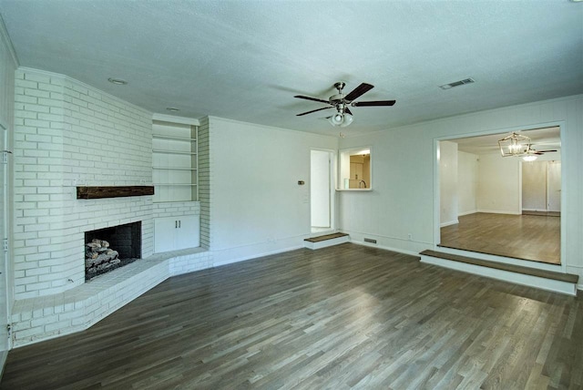 unfurnished living room with visible vents, a brick fireplace, wood finished floors, a textured ceiling, and a ceiling fan