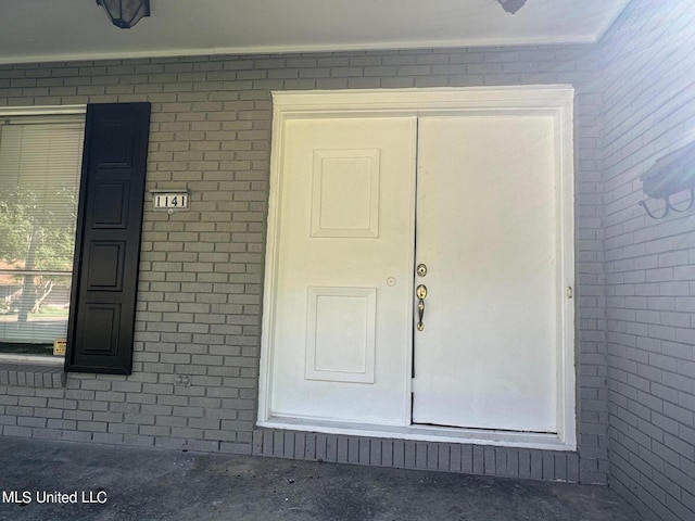 view of exterior entry with brick siding