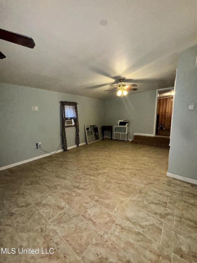 unfurnished living room featuring cooling unit, ceiling fan, and baseboards