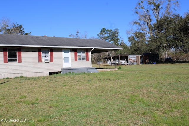 back of house featuring a carport and a lawn