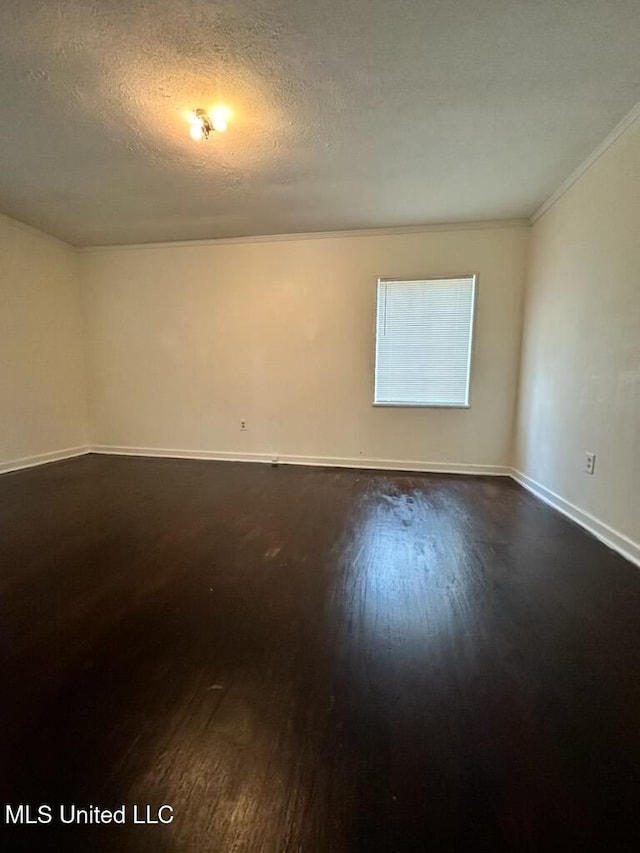 empty room featuring a textured ceiling, ornamental molding, and dark hardwood / wood-style floors