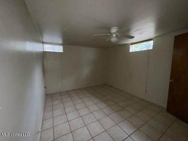 basement with ceiling fan and light tile patterned floors