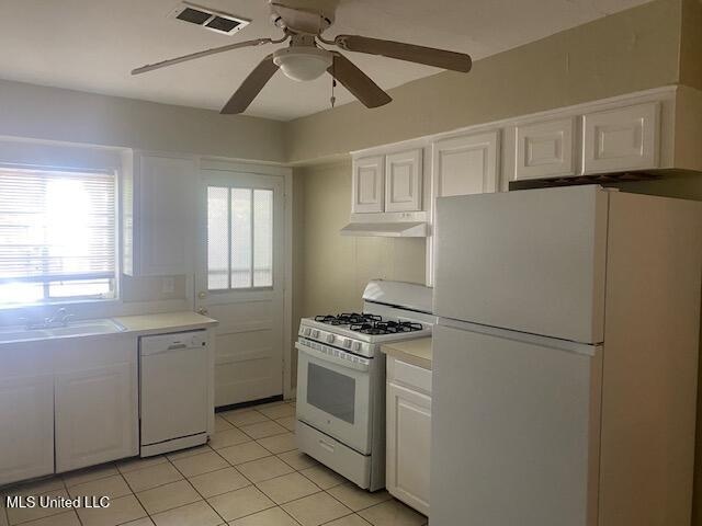 kitchen featuring sink, light tile patterned floors, ceiling fan, white cabinetry, and white appliances