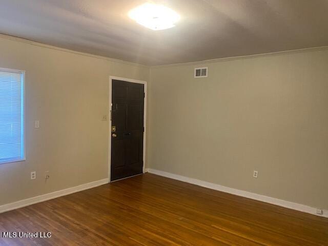 unfurnished room featuring dark hardwood / wood-style flooring and ornamental molding