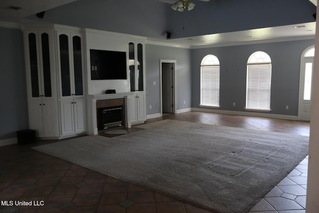 2212 Sampras Blvd, Vancleave, MS 39565 - unfurnished living room featuring tile patterned floors, ceiling fan, ornamental molding, a fireplace with flush hearth, and lofted ceiling