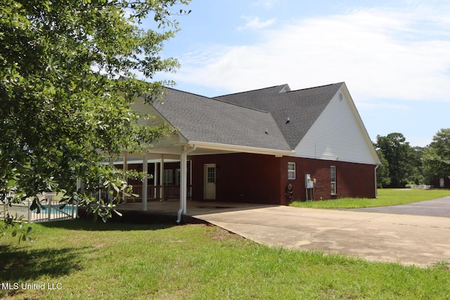 2212 Sampras Blvd, Vancleave, MS 39565 - rear view of property with concrete driveway, a yard, a carport, and roof with shingles