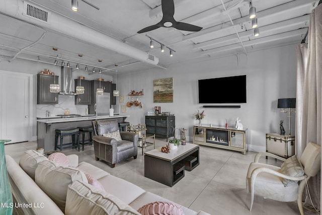 living room featuring track lighting and ceiling fan