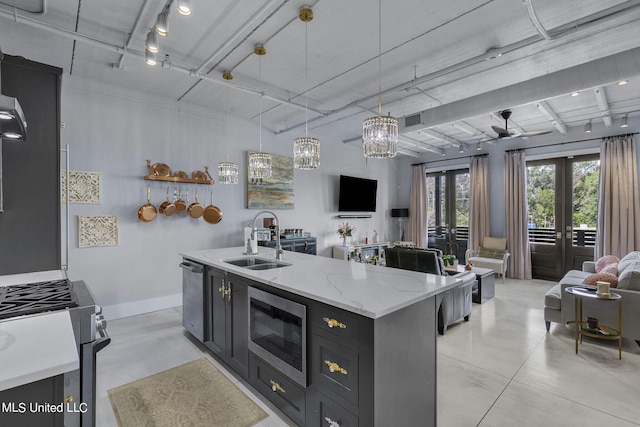 kitchen with a center island with sink, stainless steel appliances, pendant lighting, french doors, and sink