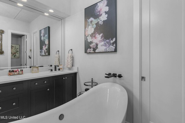 bathroom with vanity and a tub