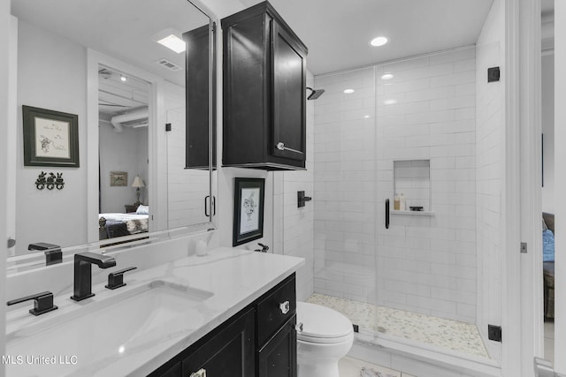 bathroom featuring vanity, toilet, and a shower with door