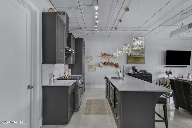 kitchen featuring appliances with stainless steel finishes, sink, decorative light fixtures, light stone counters, and ventilation hood