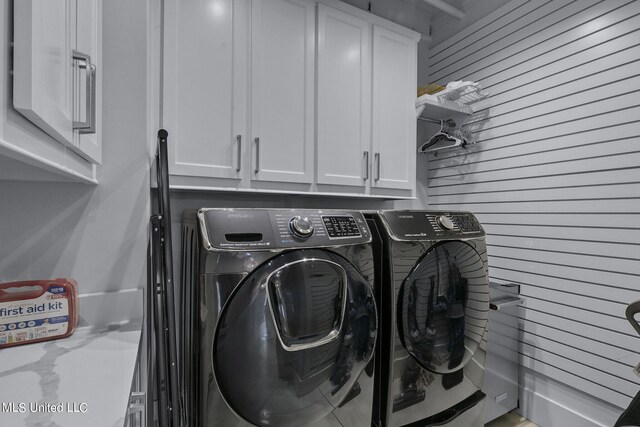 laundry area with cabinets and washer and clothes dryer