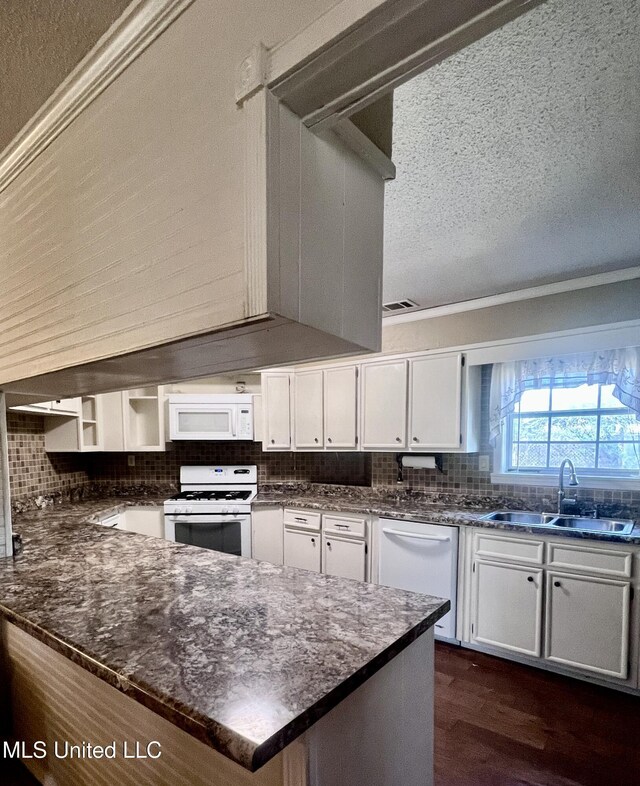 116 E Tate St, Senatobia, MS 38668 - kitchen with decorative backsplash, white cabinets, a sink, and white appliances