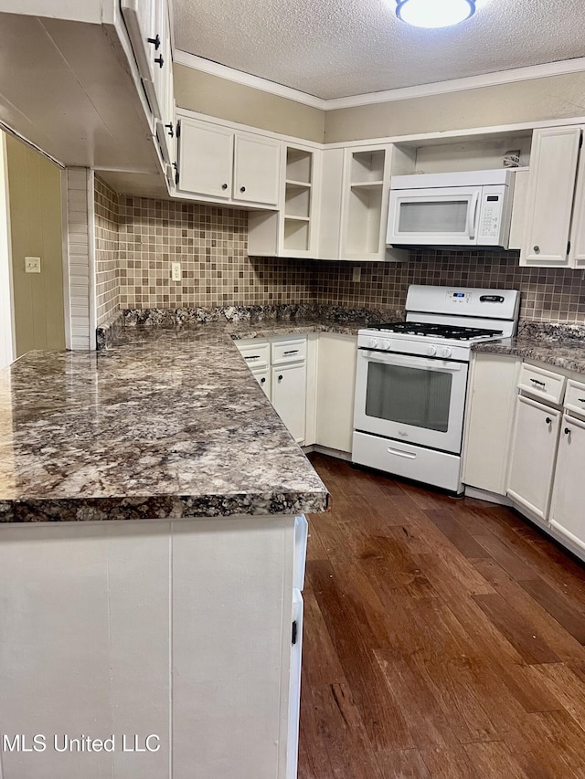 116 E Tate St, Senatobia, MS 38668 - kitchen with open shelves, dark wood-style floors, white appliances, white cabinets, and decorative backsplash