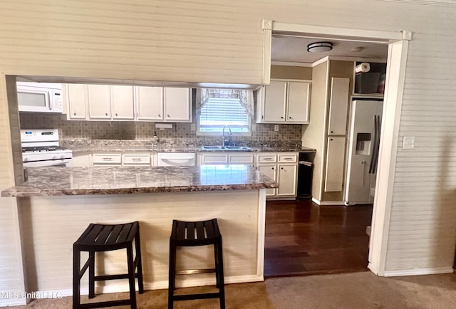 116 E Tate St, Senatobia, MS 38668 - kitchen featuring a sink, a breakfast bar area, light stone countertops, white appliances, and white cabinets