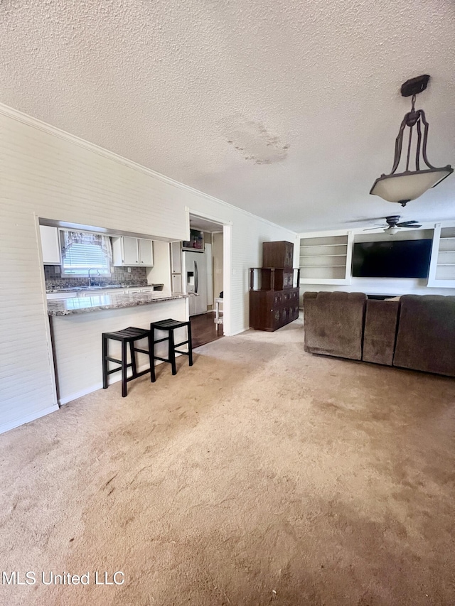 116 E Tate St, Senatobia, MS 38668 - living area featuring carpet flooring, a ceiling fan, ornamental molding, and a textured ceiling