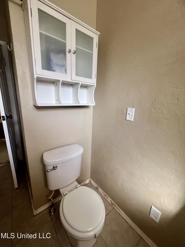 116 E Tate St, Senatobia, MS 38668 - bathroom with toilet, a textured wall, tile patterned floors, and baseboards