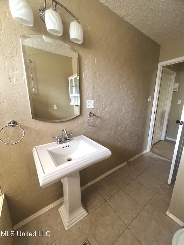 116 E Tate St, Senatobia, MS 38668 - bathroom featuring tile patterned flooring, a textured wall, baseboards, and a textured ceiling