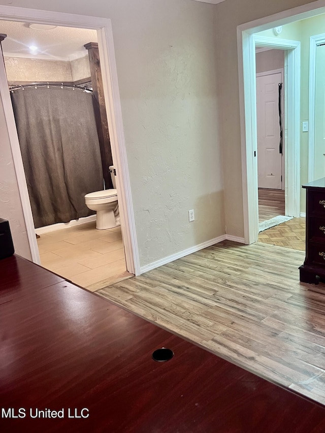 116 E Tate St, Senatobia, MS 38668 - bathroom with a shower with curtain, toilet, wood finished floors, and a textured wall