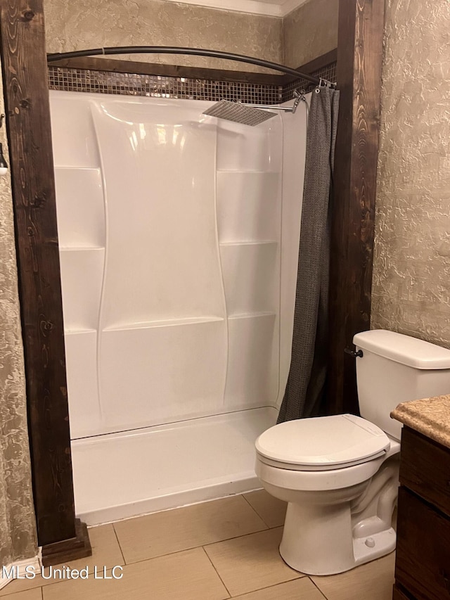 116 E Tate St, Senatobia, MS 38668 - full bathroom with vanity, toilet, a textured wall, a shower with shower curtain, and tile patterned floors