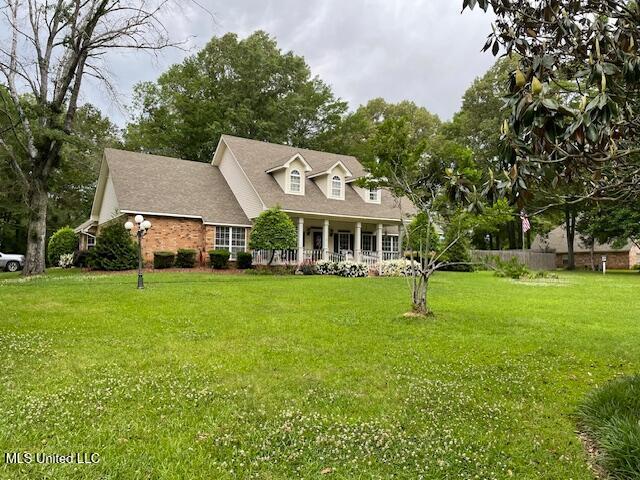 cape cod home featuring a porch and a front yard