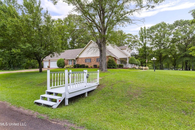 view of grassy yard featuring concrete driveway and an attached garage