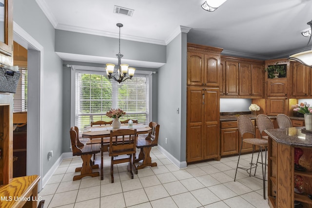 kitchen with a chandelier, crown molding, brown cabinetry, dark stone counters, and pendant lighting