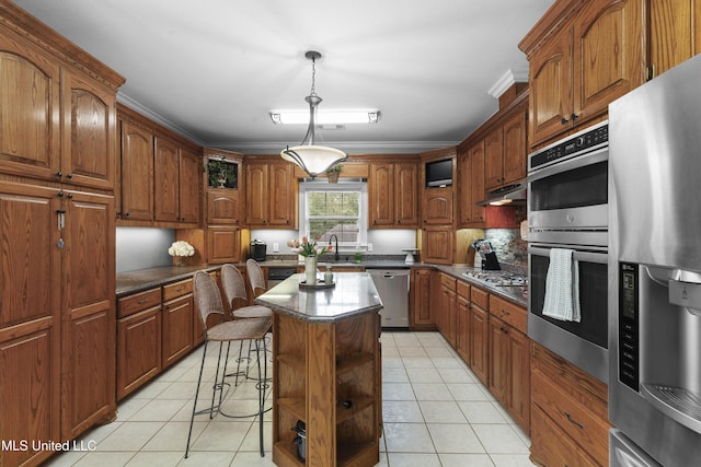 kitchen with stainless steel appliances, light tile patterned floors, a kitchen island, and under cabinet range hood