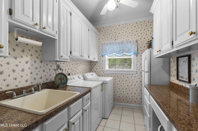 washroom with wallpapered walls, washing machine and dryer, a ceiling fan, ornamental molding, and light tile patterned flooring