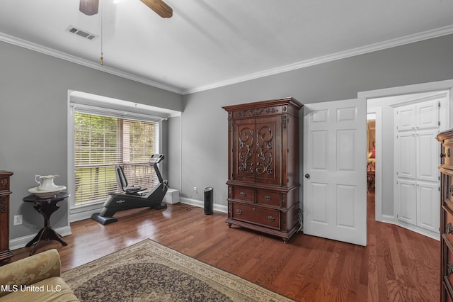 sitting room featuring dark wood-style floors, crown molding, a ceiling fan, and baseboards