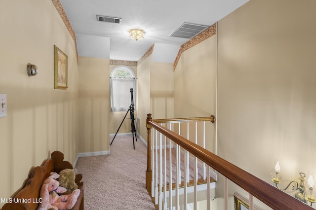 corridor with an upstairs landing, carpet, and baseboards