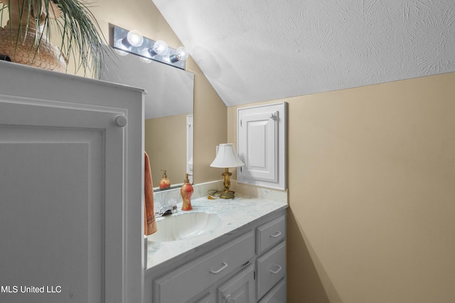 bathroom with lofted ceiling and vanity